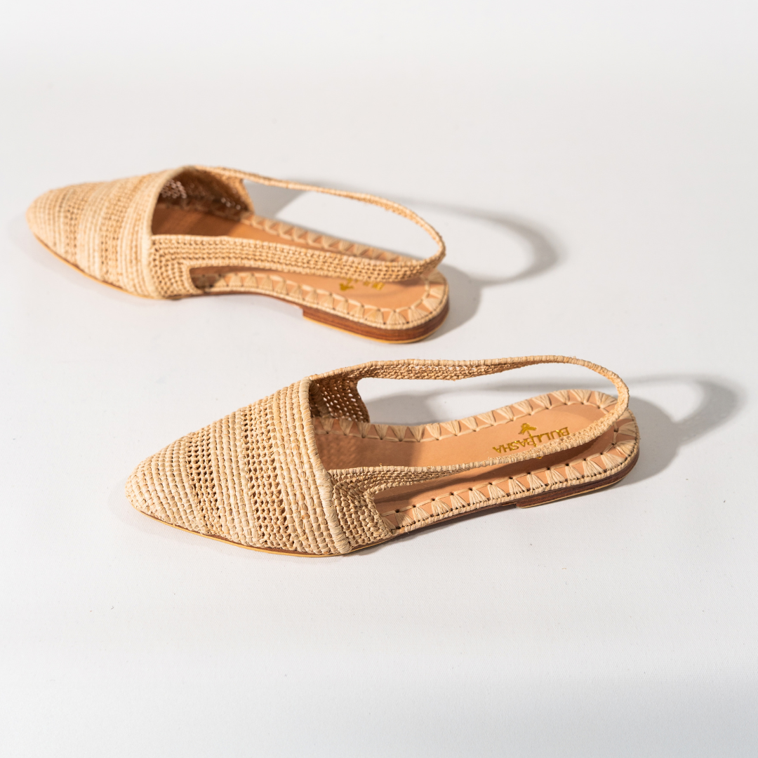 Amaynu flats angled from above, the leather insole and open back visible