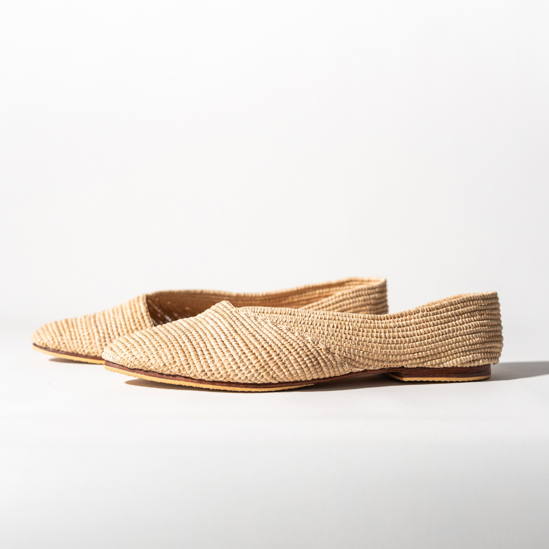 Ayyur flats angled on white, the woven texture of the upper in close view