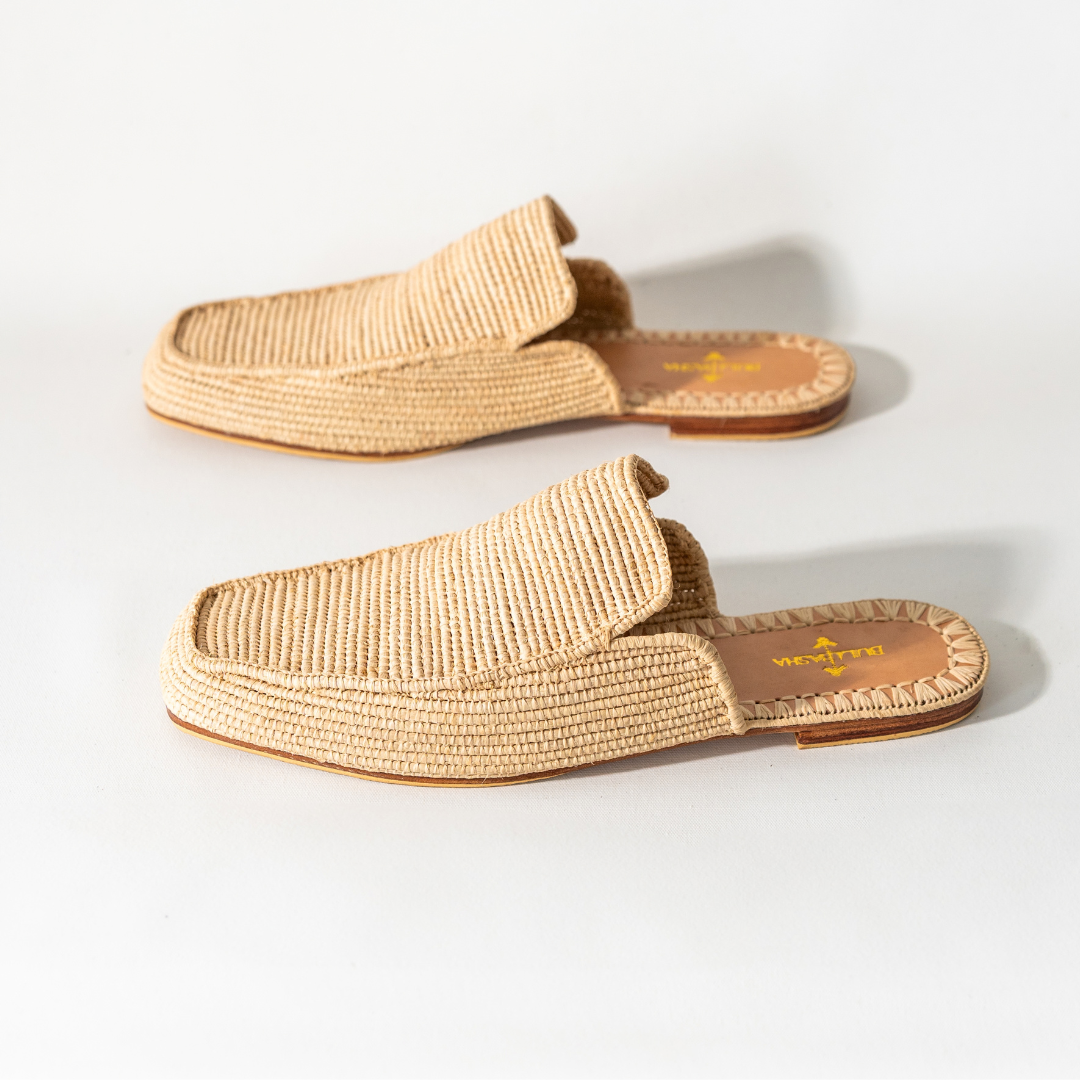 Munatas men's mules angled on white, the woven upper and leather insole visible